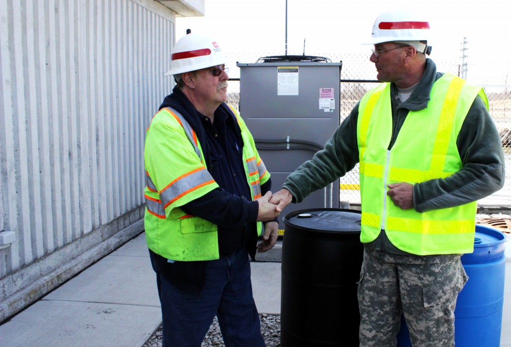 Command Sgt. Maj. Karl J. Groninger, command sergeant major, U.S. Army Corps of Engineers, Headquarters, presents John McGowan, Electric Barriers facility manager, with a coin for his continued diligence and attention to safety on the job, Romeoville, Ill., March 20, 2014. (U.S. Army Photo by Sarah Gross/Released)